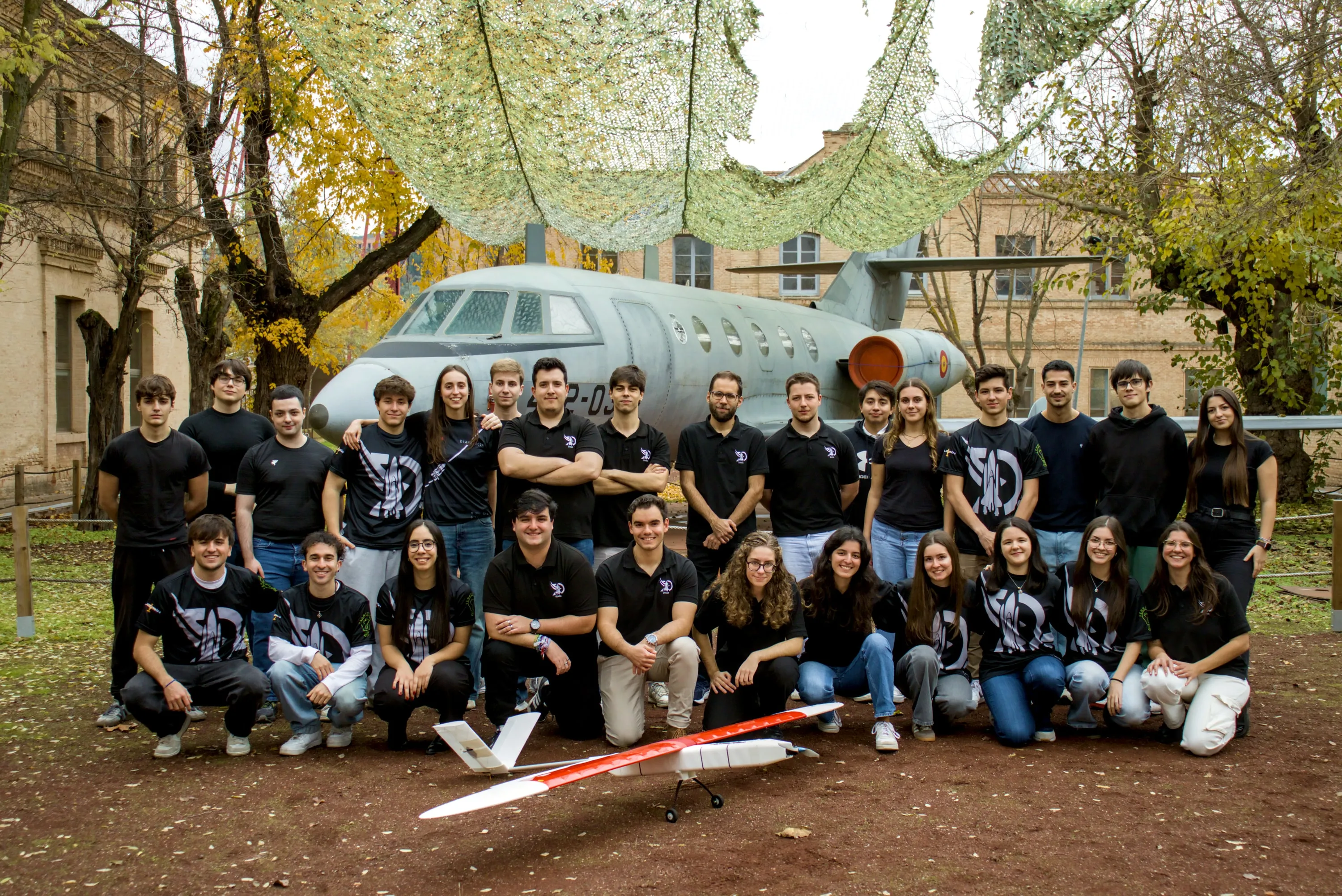 El equipo de DIANA posa con el Aurora delante de un avión de exposición